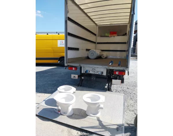 Trois urinoirs sont chargés dans un camion